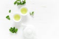 Green mint tea with fresh leaves in cups and teapot overhead on white wooden table, healthy warming drink, antioxidant beverage Royalty Free Stock Photo