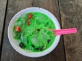 green mixed fruits ice dessert, consisting of watermelon pieces and black jelly pieces. in a white bowl a red spoon. Top view Royalty Free Stock Photo