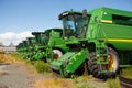 green modern combine harvester on stubble field at end of summer.