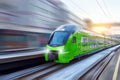 White modern high speed train in motion on railway station at sunset. Train on railroad track with motion blur effect in Europe in Royalty Free Stock Photo