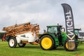 Green modern tractor pulling a knight crop sprayer