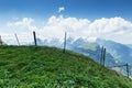 Green mountain meadow in front of barbed wire fence and view to Royalty Free Stock Photo