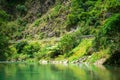 A green mountain river flowing along a forested cliffs of a gorge. Waioeka Gorge, North Island, New Zealand Royalty Free Stock Photo