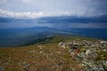 green mountains covered with forest, storm clouds, view from the top with stone