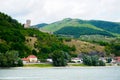 Green mountains on Danube beach and old castle ruins.