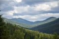 Green mountains and grassy meadow on the valley surrounded by coniferous forest on the hills. Carpathians Royalty Free Stock Photo