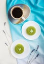 Green mousse cake with pistachio cream and a cup of coffee on a white wooden background. top view, close up Royalty Free Stock Photo