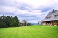 Green mown the lawn in front of a wooden house Royalty Free Stock Photo