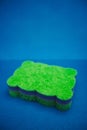 Green multifunctional sponge on a blue background