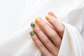 Green nail design. Female hand with color manicure