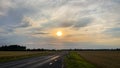 Green national agricultural field and forest in the sunset sky with cumulus clouds. The road is visible. Classic cloud view Royalty Free Stock Photo