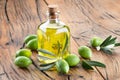 Green natural olives with bottle of olive oil on a vintage old wooden table Royalty Free Stock Photo