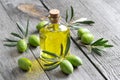 Green natural olives with bottle of olive oil on a vintage old wooden table Royalty Free Stock Photo