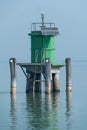 Green Navigation Beacon with Solar Panel in Calm Lagoon Water, Venice, Italy Royalty Free Stock Photo