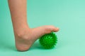 green needle ball for massage and physical therapy on a green background with a child& x27;s foot, the concept of Royalty Free Stock Photo