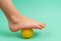 green needle ball for massage and physical therapy on a green background with a child& x27;s foot, the concept of Royalty Free Stock Photo