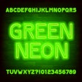 Green Neon alphabet font. Simple neon color letters and numbers. Brick wall background.