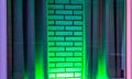 Green neon light shining on a white brick wall with curtains, modern decorative background Royalty Free Stock Photo