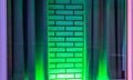 Green neon light shining on a white brick wall with curtains, modern decorative background Royalty Free Stock Photo