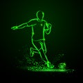 Green Neon soccer striker. Football player hits the ball in the dark under the rain