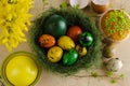 Green nest with many different colored quail easter eggs and muffin with sprinkles on the top.