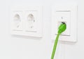 Green network cable in wall outlet for office or private home lan ethernet connection with power outlets flat view on white