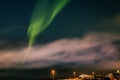 Green northern lights over Hafnarfjordur town, Iceland.