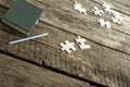 Green note pad, pencil and scattered puzzle pieces lying on a te Royalty Free Stock Photo