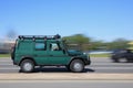 Green off-road vehicle Mercedes g class is driving on the street. Side view. Motion blur. Riga, Latvia - 15 Jun 2021