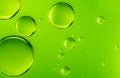 Green oil drops in water. Bubbles of different sizes on green background Royalty Free Stock Photo