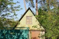 Green old wooden attic of a rural house with a window behind a fence Royalty Free Stock Photo