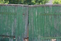 Green old wooden closed gate with broken boards Royalty Free Stock Photo