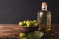 Green olives, bay leaf . Olive oil in a glass bottle.. Olives on a black background.