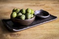 Green olives in a ceramic bowl on a wooden background. Royalty Free Stock Photo