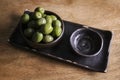 Green olives in a ceramic bowl on a wooden background. Royalty Free Stock Photo