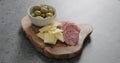 Green olives, cheese and salami on olive wood board Royalty Free Stock Photo