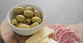 Green olives, cheese and salami on olive wood board Royalty Free Stock Photo