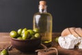 Green olives, sliced ciabatta, feta cheese on a wooden board. Olive oil in a glass bottle