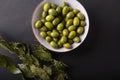 Green olives in a white bowl on a black background. Royalty Free Stock Photo