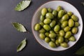 Green olives in a white bowl on a black background. Royalty Free Stock Photo