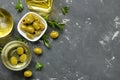 Green olives in a white ceramic bowl with leaves on a dark graphite background. top view. space for text Royalty Free Stock Photo