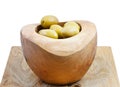Green olives in wooden bowl on board isolated Royalty Free Stock Photo