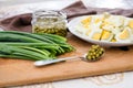 Green onions, chopped eggs on a plate and canned peas on a wooden board. The concept of cooking spring salad. Royalty Free Stock Photo