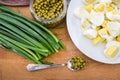 Green onions, chopped eggs on a plate and canned peas on a wooden board. The concept of cooking spring salad. Royalty Free Stock Photo