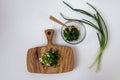 Green onions on a wooden cutting board, in a glass plate with a bunch of onions on a white background - the concept of the Royalty Free Stock Photo