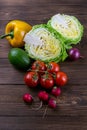 Green onions, yellow peppers, cherry tomatoes, slot and cabbage on dark wooden table. Top views, close-up Royalty Free Stock Photo