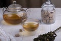 Green oolong tea with fruit in a glass clear cup and glass teapot, brown sugar, close-up, selective focus on the cup Royalty Free Stock Photo
