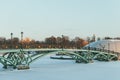 Green openwork metal arcuate bridge over a frozen reservoir in Tsaritsino park in Moscow in Russia. Winter scenery