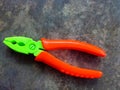 Green and orange plastic children& x27;s toy pliers on the cement floor Royalty Free Stock Photo