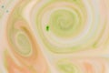 Green and orange swirls in white liquid Royalty Free Stock Photo